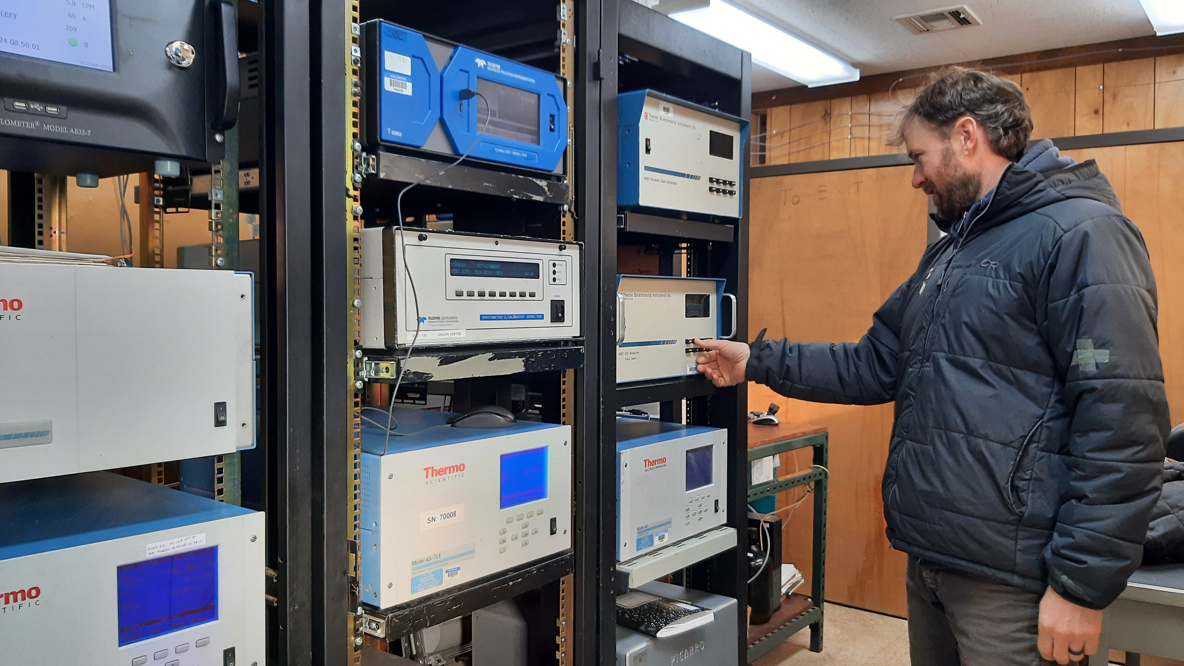 A research scientist at Whiteface Mountain looks at air quality equipment